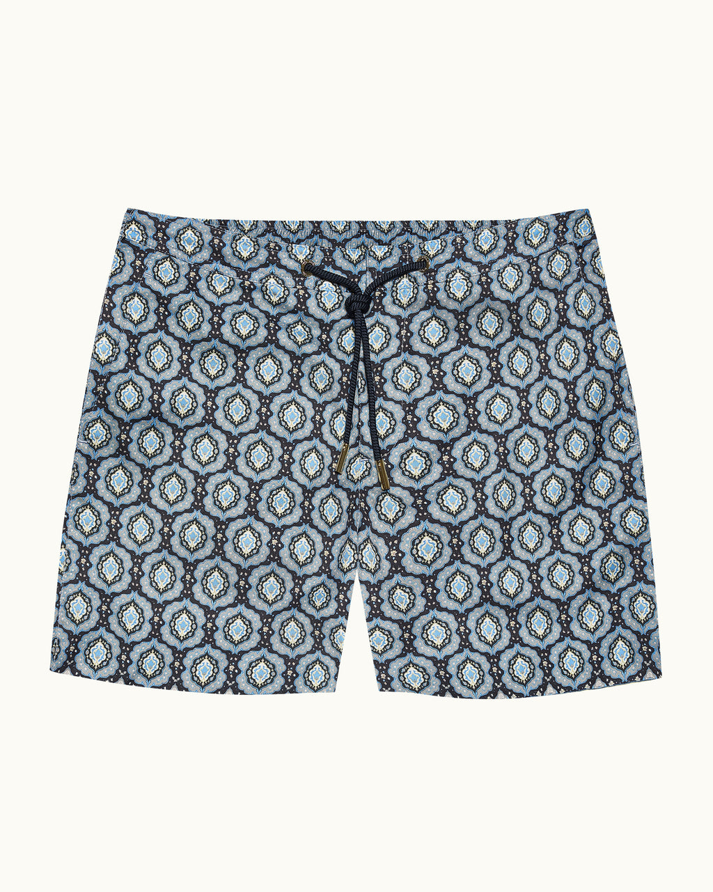 Blue patterned swim shorts on a beige background
