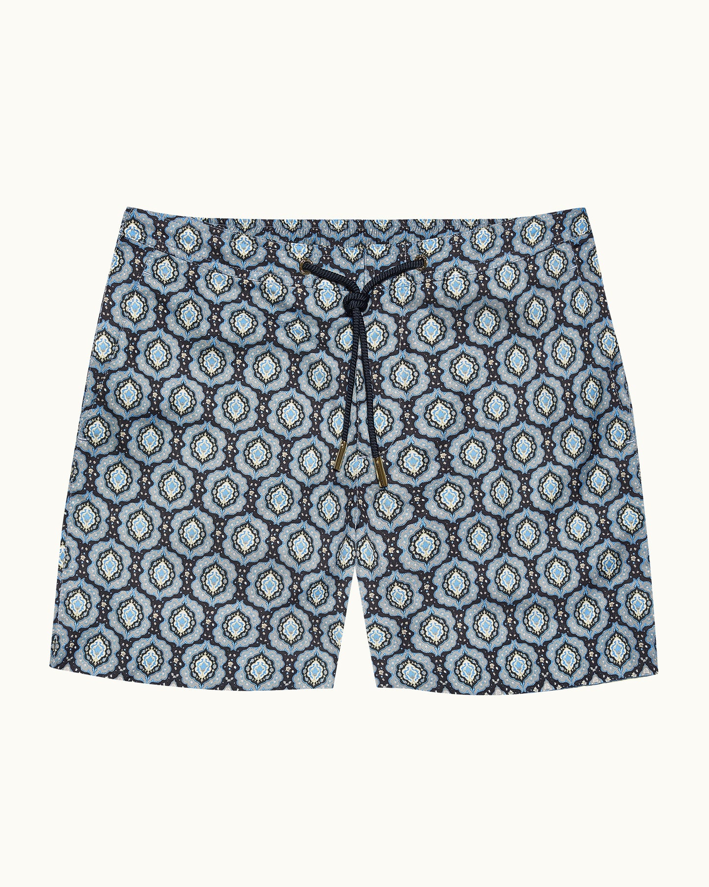 Blue patterned swim shorts on a beige background