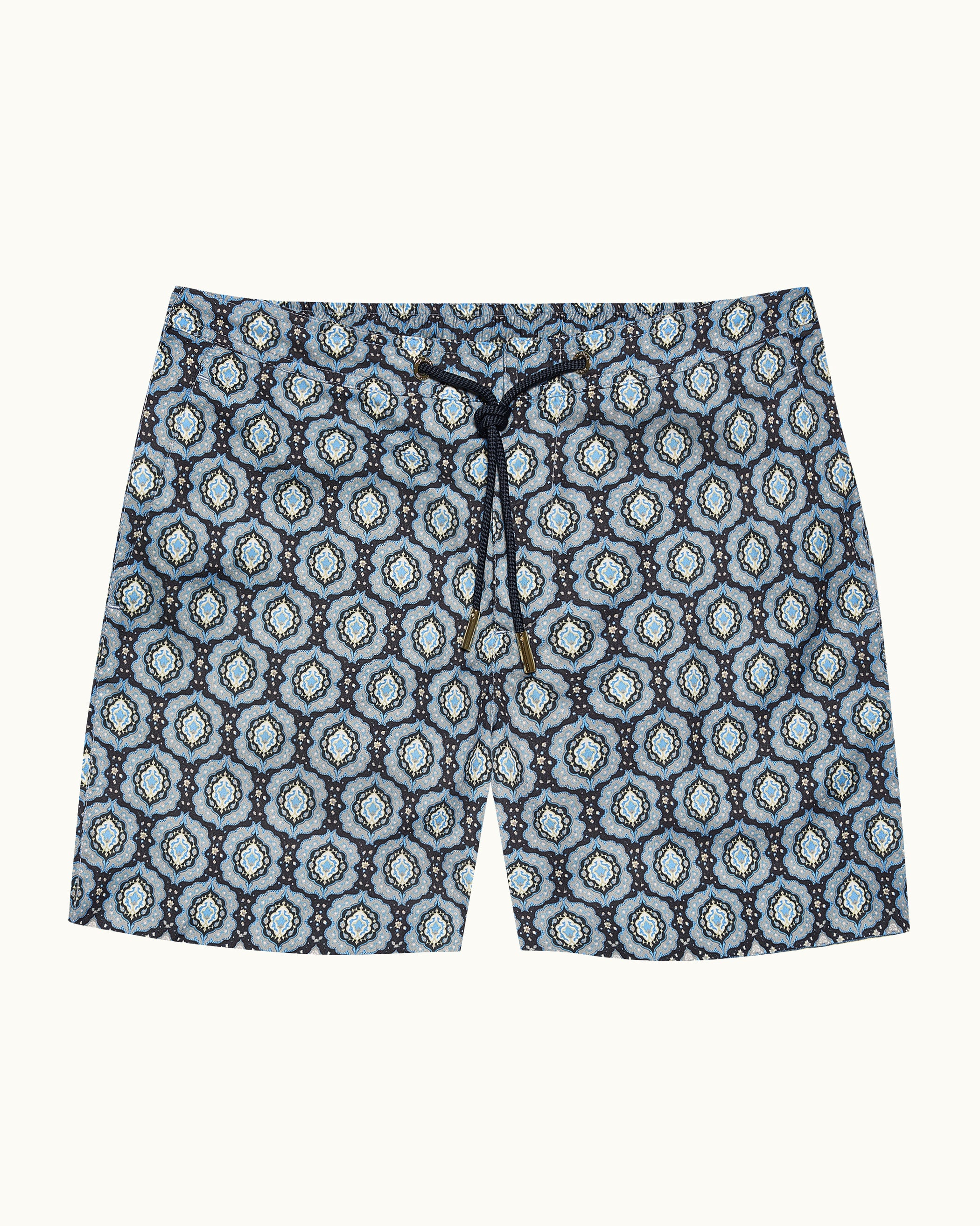 Blue patterned swim shorts on a beige background