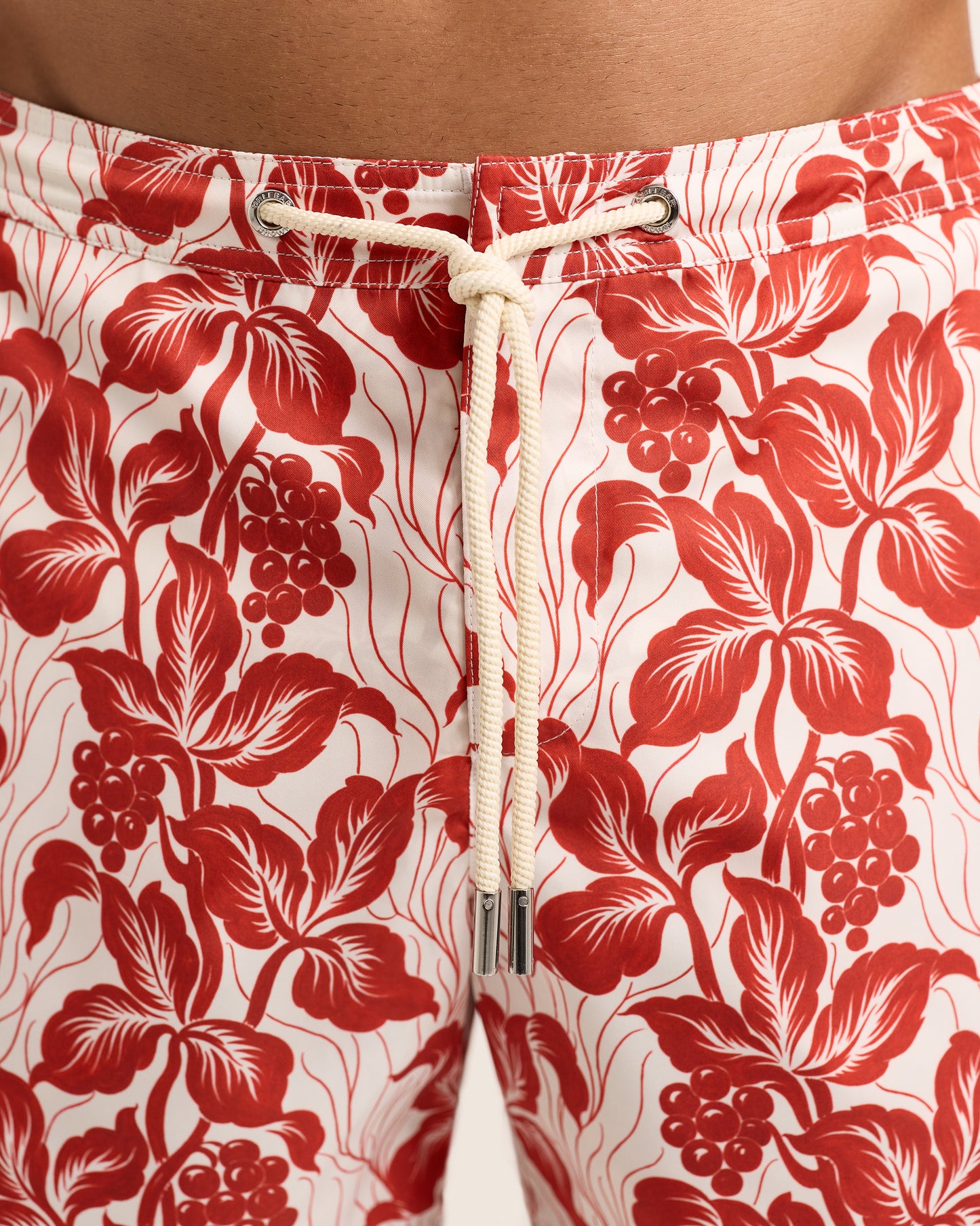 Red floral patterned shorts with a white drawstring on a red background