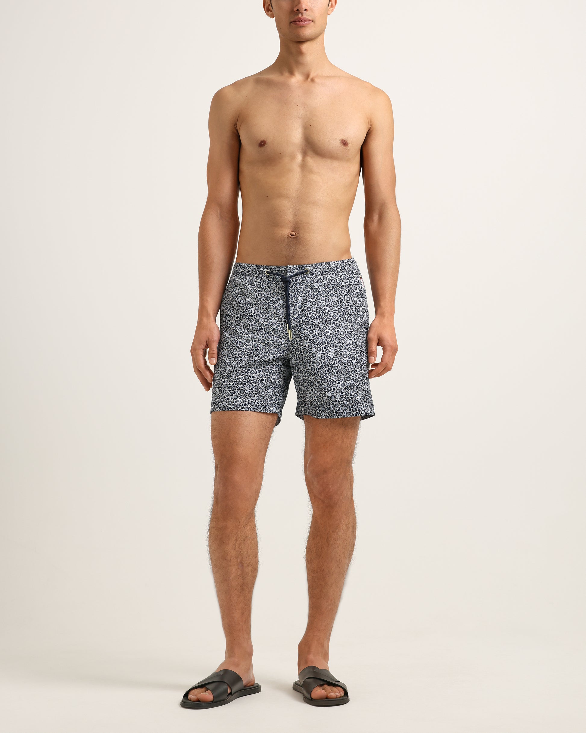 Man wearing patterned shorts on a plain background