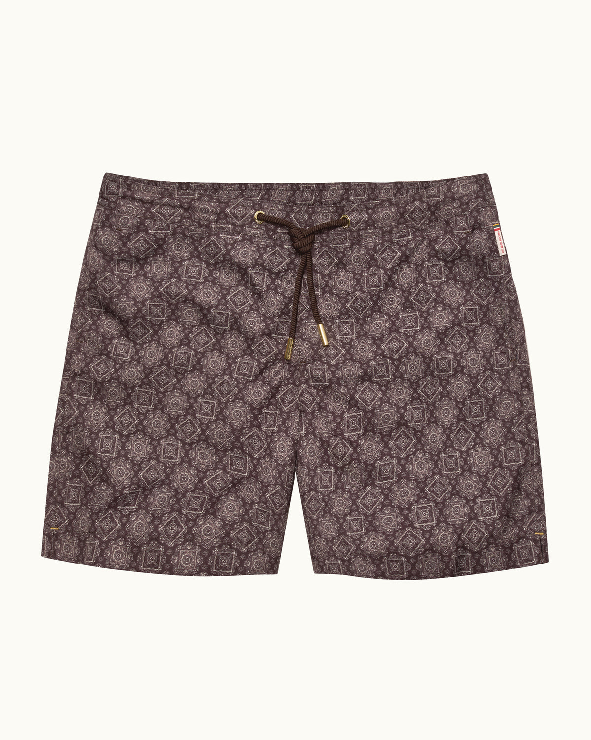 A pair of men's swim trunks featuring an all-over geometric medallion pattern in dark brown and black, with a matching dark brown drawstring waist and small gold-colored metal tips.