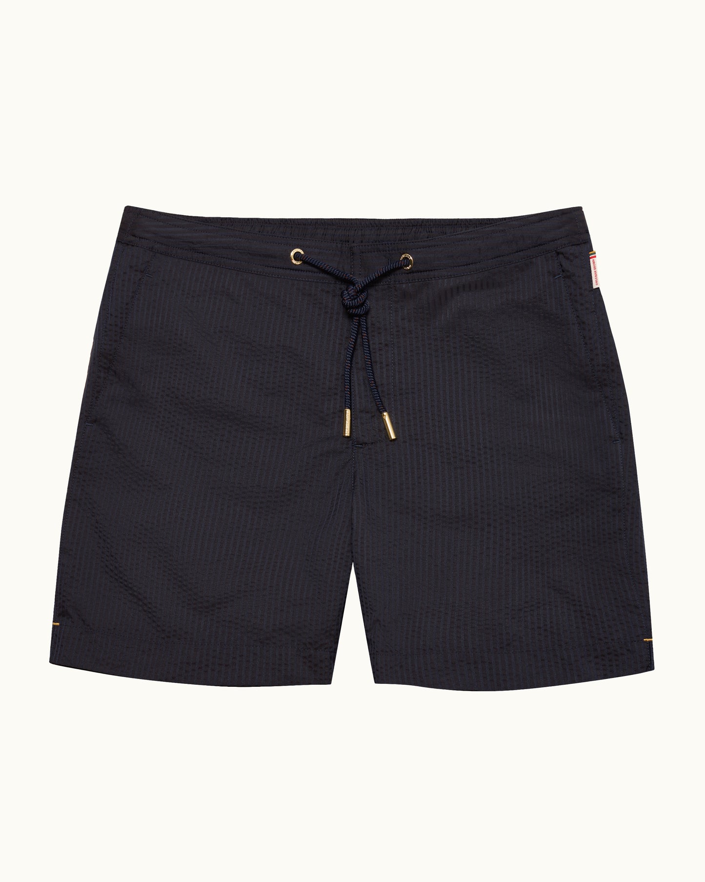 Black textured drawstring board shorts with gold-tone eyelets and tips, shown flat against a light off-white background.