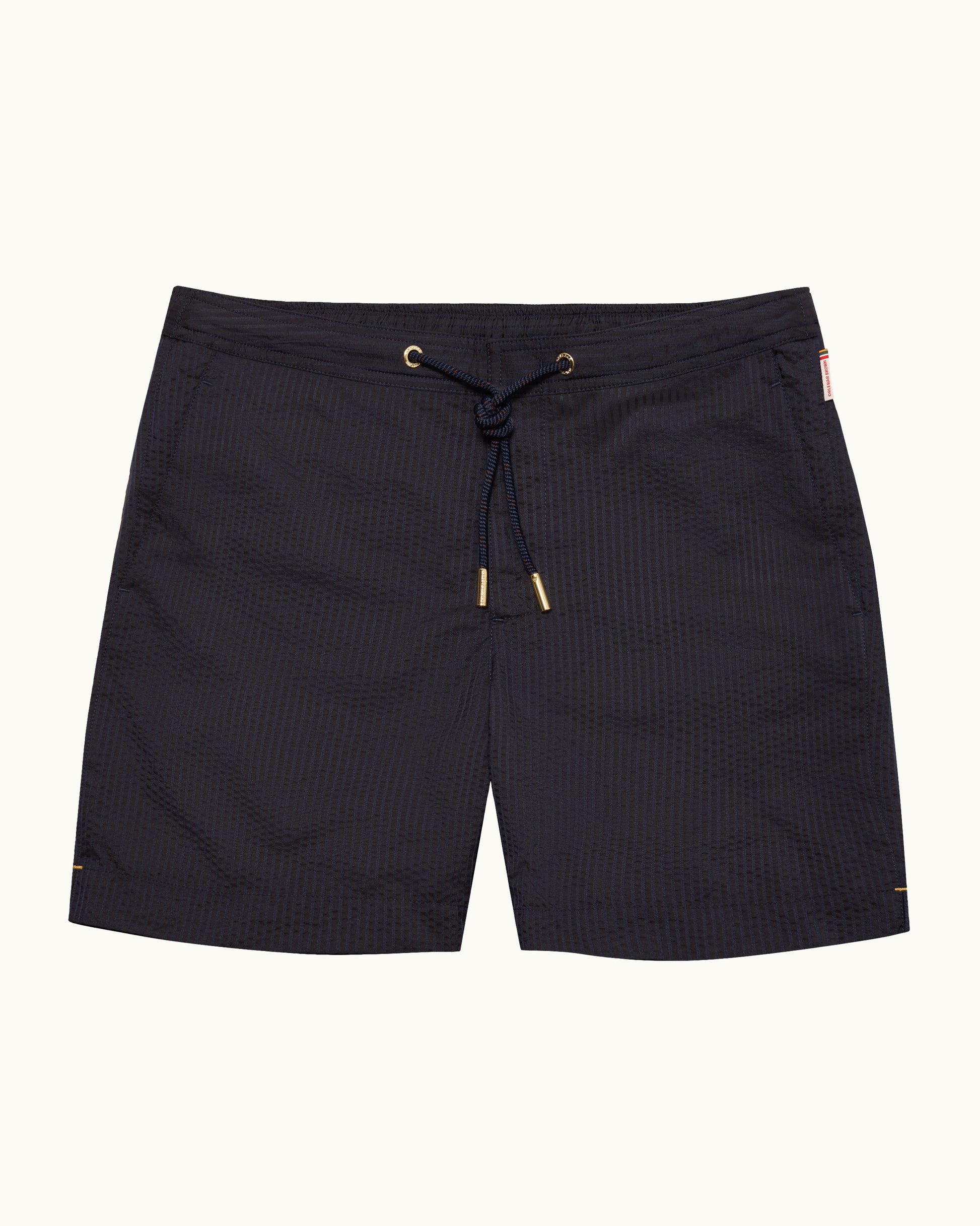 Black textured drawstring board shorts with gold-tone eyelets and tips, shown flat against a light off-white background.