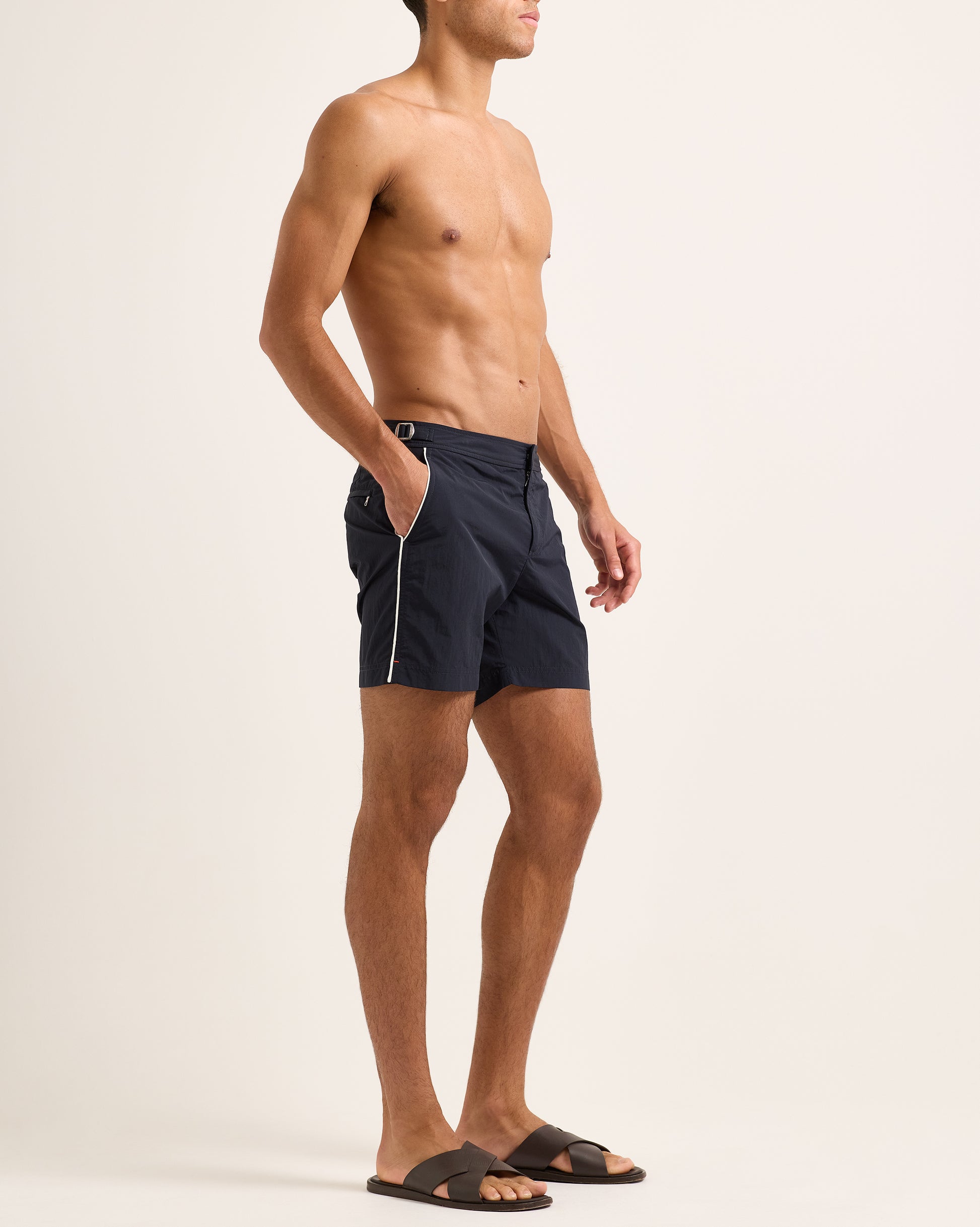 Man wearing navy shorts with white side stripe on a white background