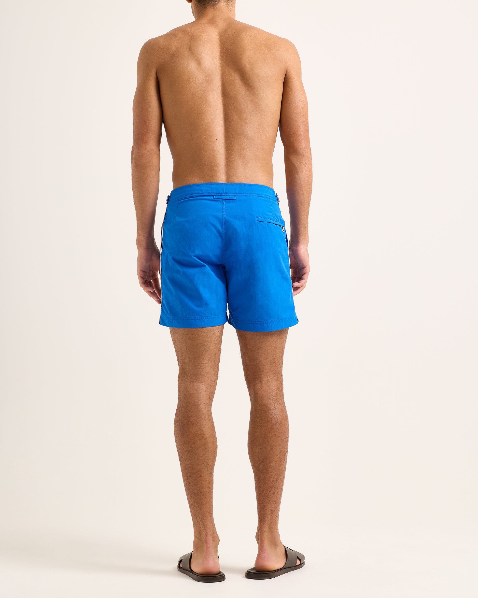 Man wearing blue shorts with white stripes on a white background