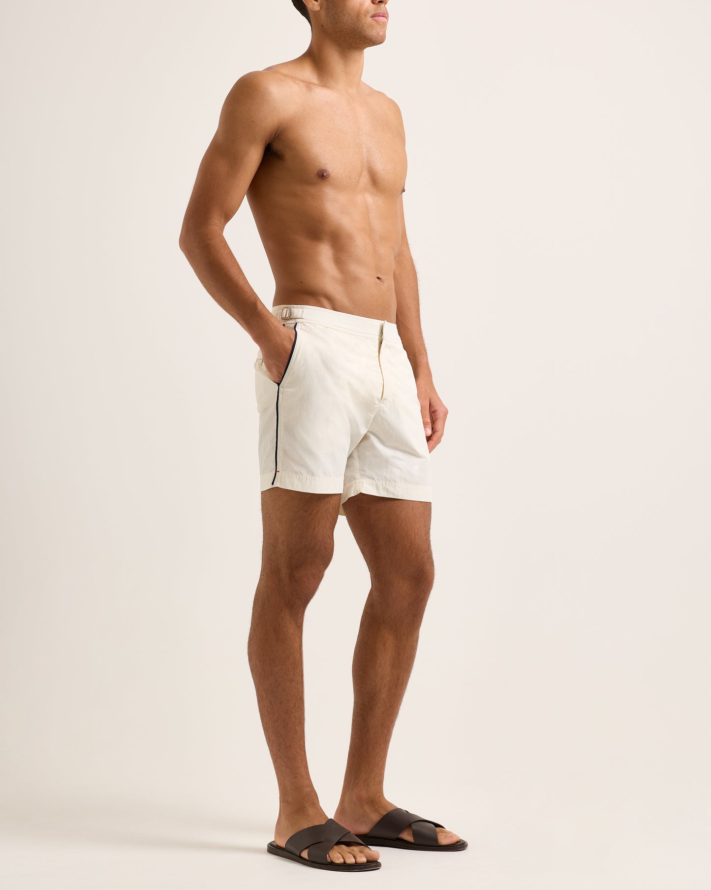 Man wearing white shorts with a black stripe on a plain background