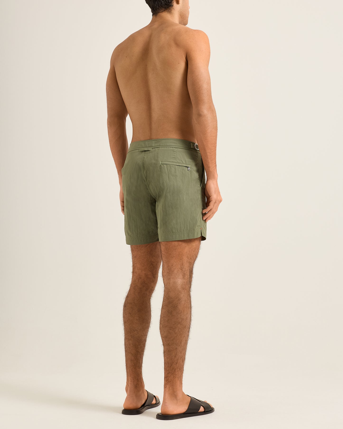 Man wearing green shorts on a beige background