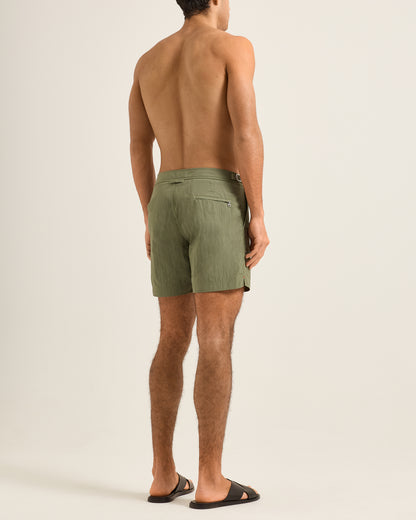 Man wearing green shorts on a beige background