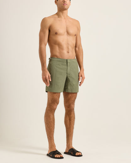 Man wearing green shorts on a plain background