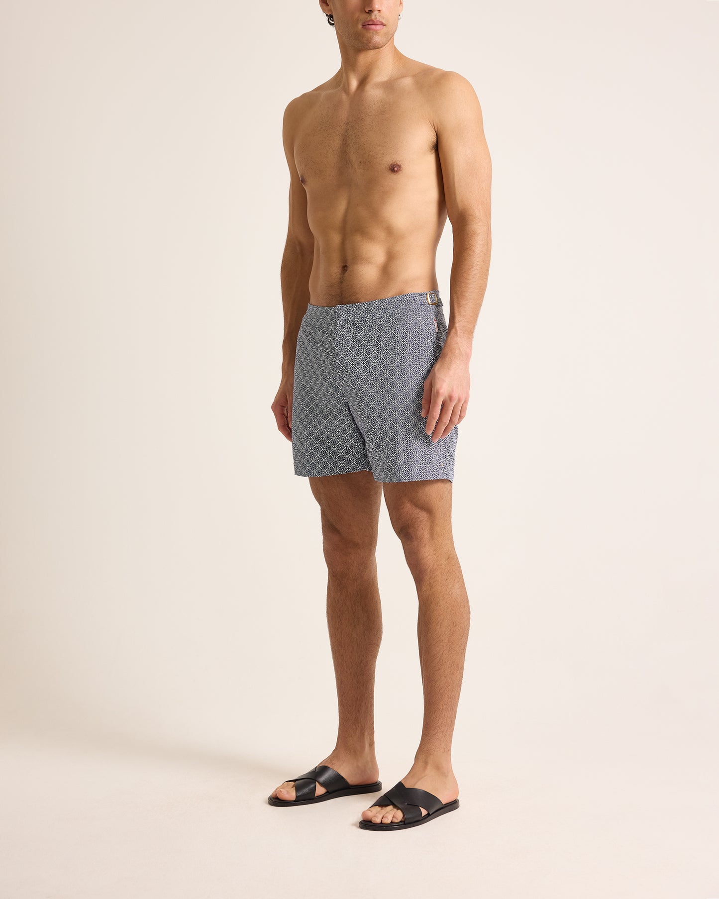 Man wearing patterned swim shorts on a beige background