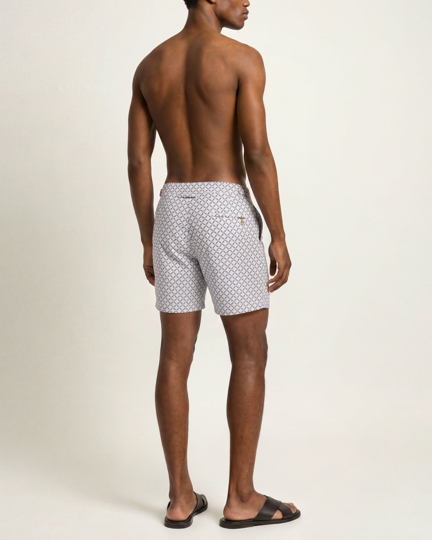 Back shot of a model wearing patterned jacquard white swim shorts 