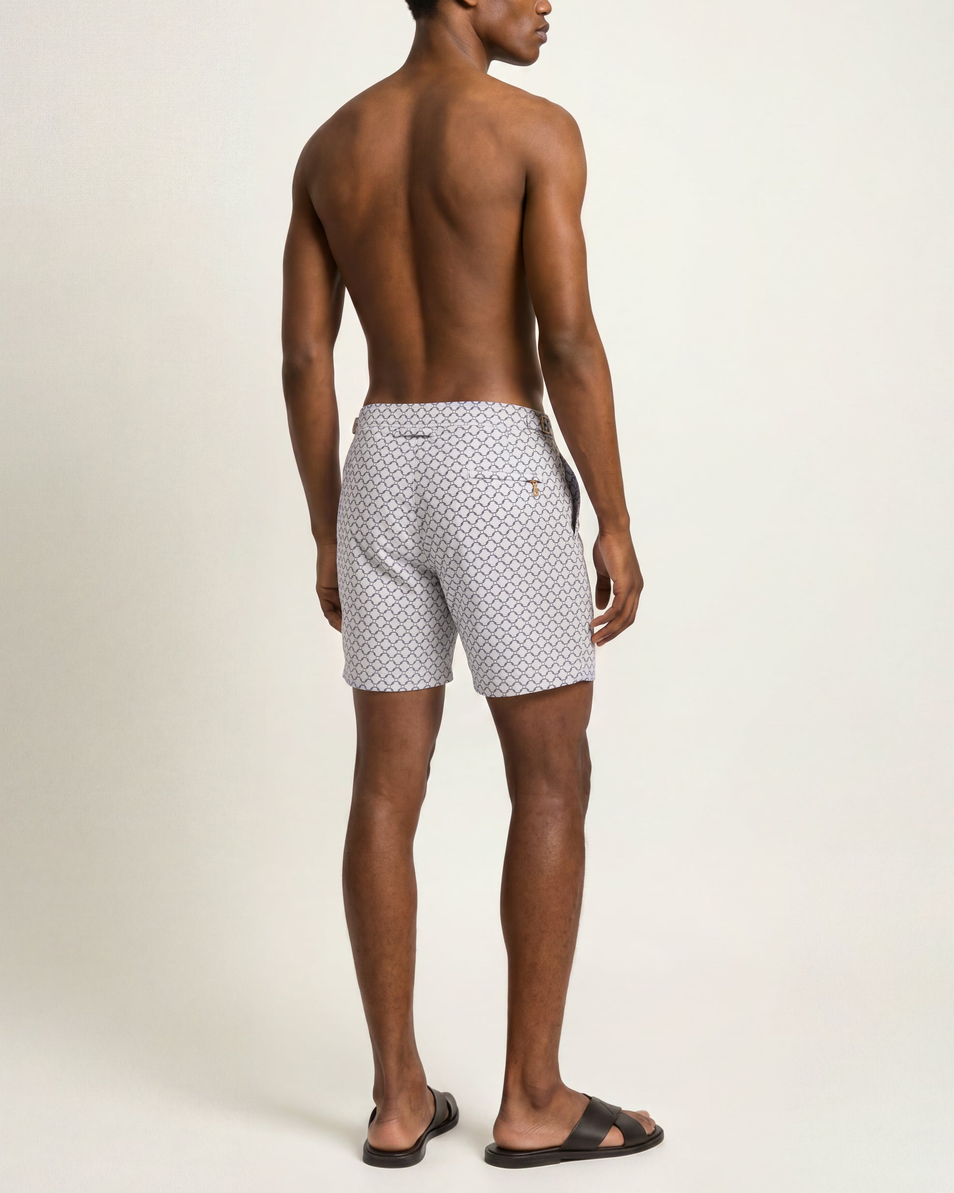 Back shot of a model wearing patterned jacquard white swim shorts 