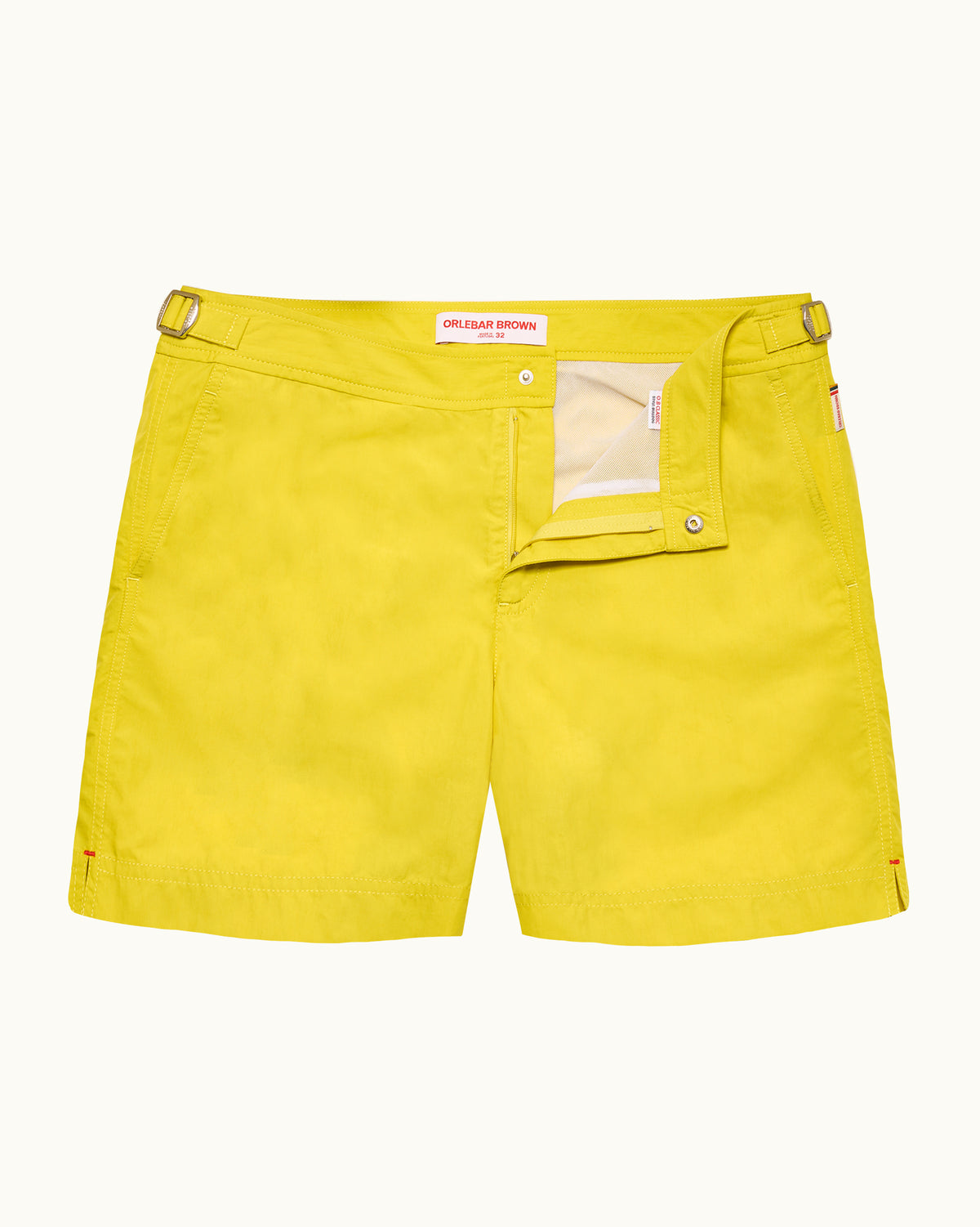 Yellow swim shorts with silver side adjusters on a plain background