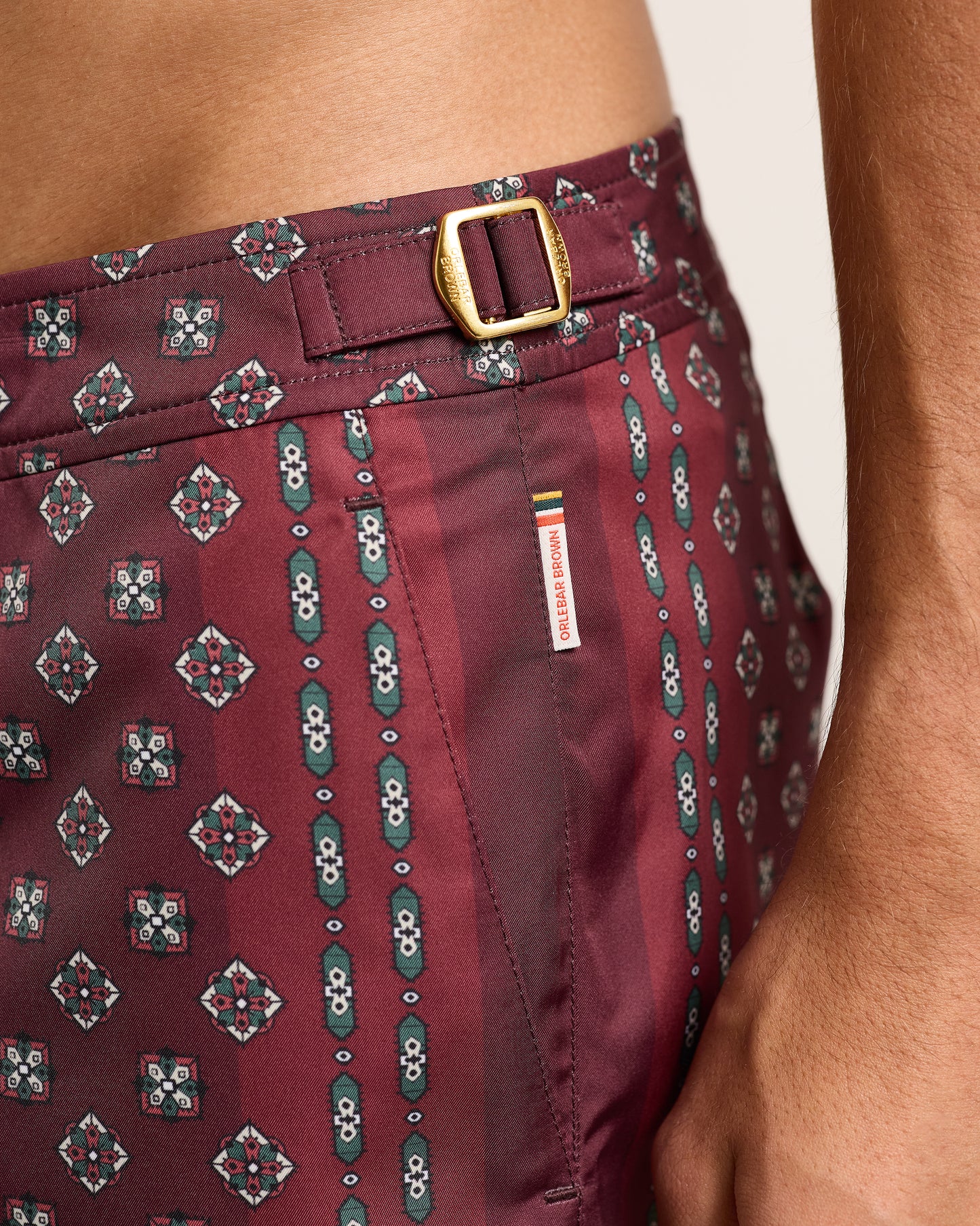 Maroon patterned shorts with a belt and visible brand label.