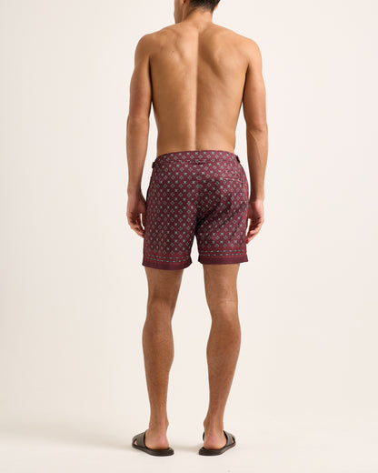 Man wearing patterned shorts on a plain background
