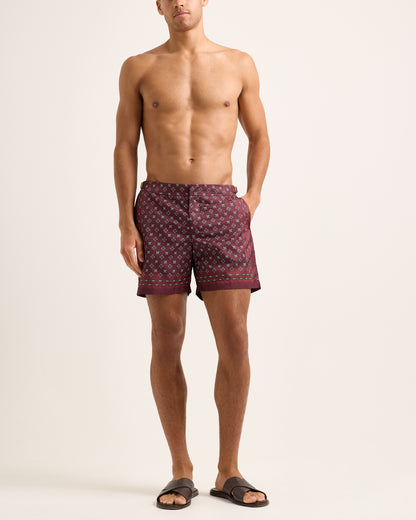 Man wearing patterned shorts on a plain background