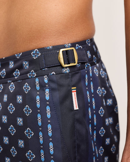 Navy shorts with blue geometric pattern and gold buckle on a white background