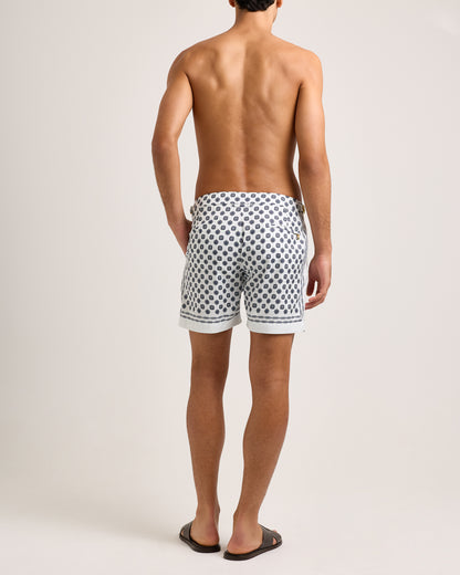 Man wearing white shorts with blue geometric pattern on a white background