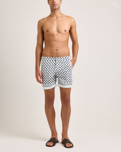 Man wearing white shorts with blue geometric pattern on a white background