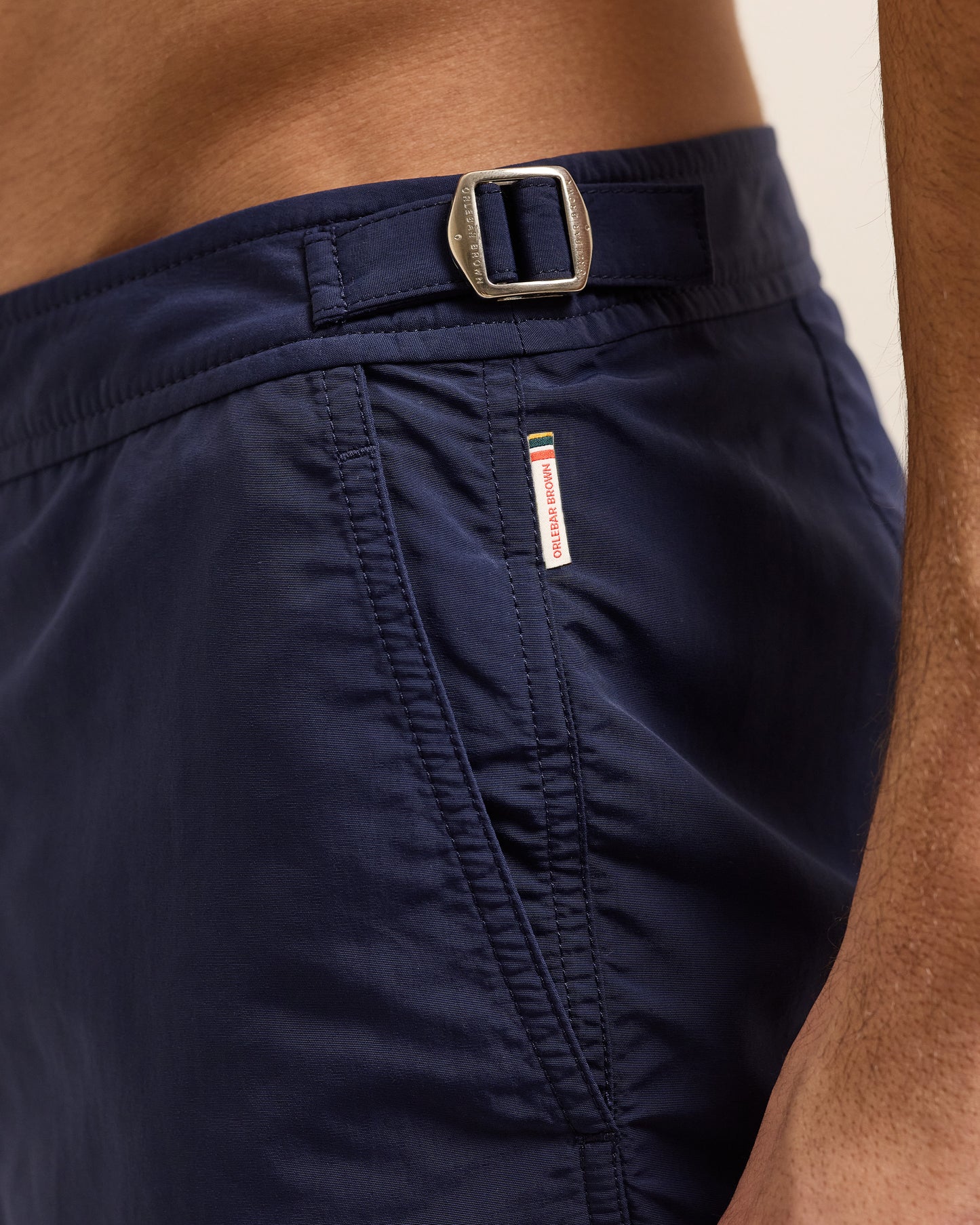 Closeup of navy swim short with silver side adjuster