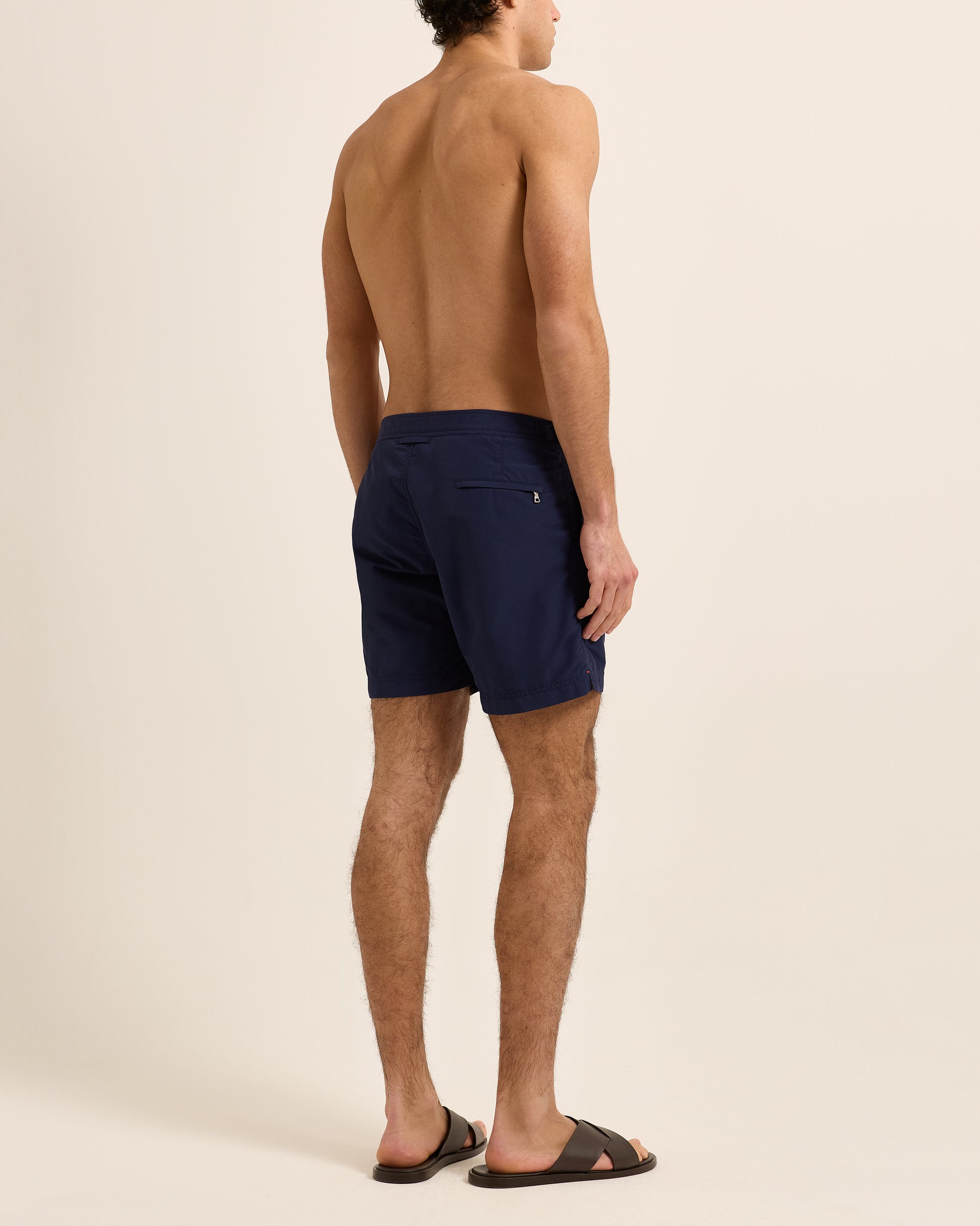 Man wearing navy swim shorts on a white background