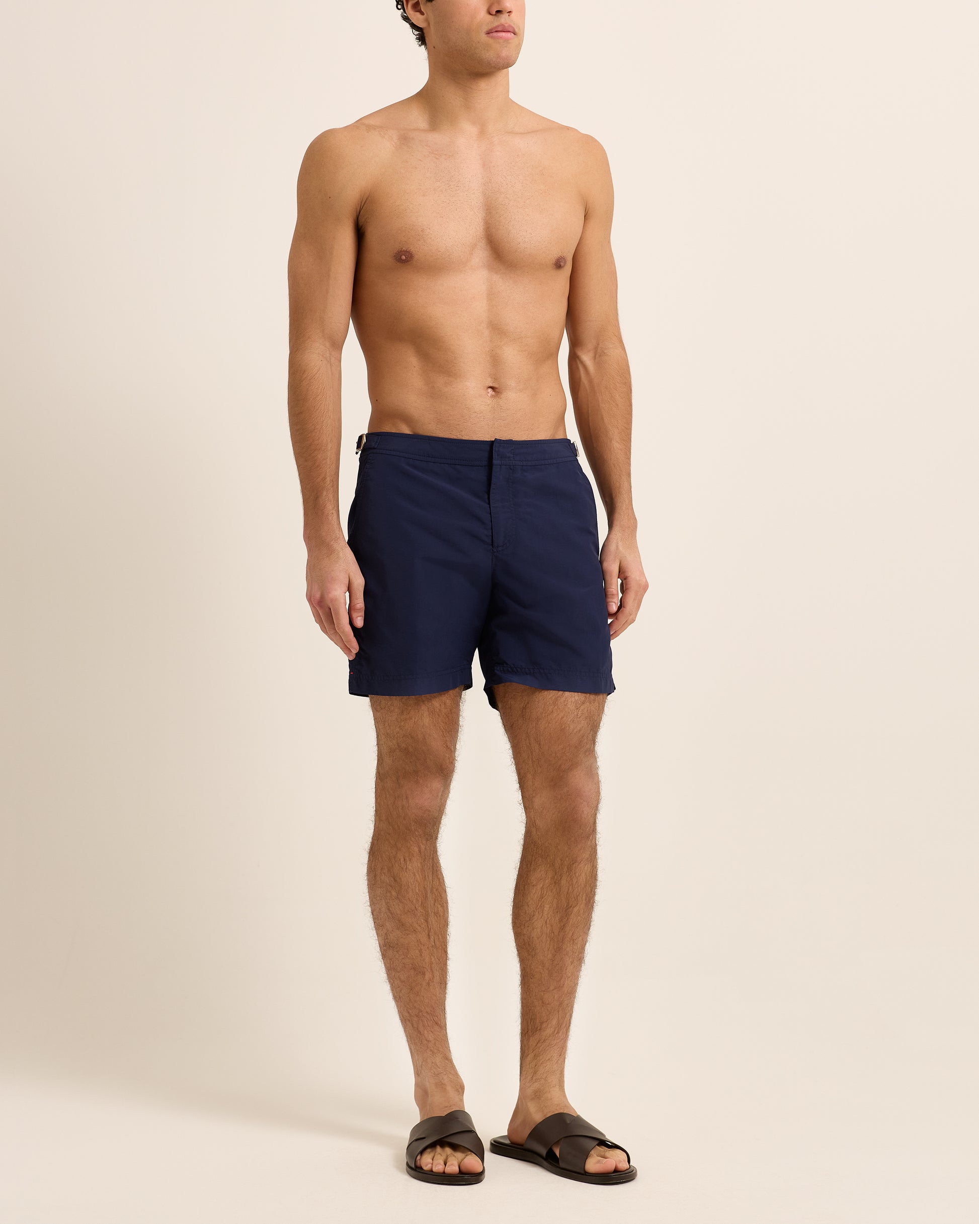 Man wearing navy swim shorts on a white background