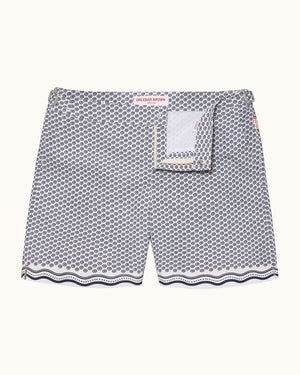 A pair of men's swimshorts featuring a gray and white geometric pattern with a scalloped wavy hem and a matching fabric pocket detail on the front.