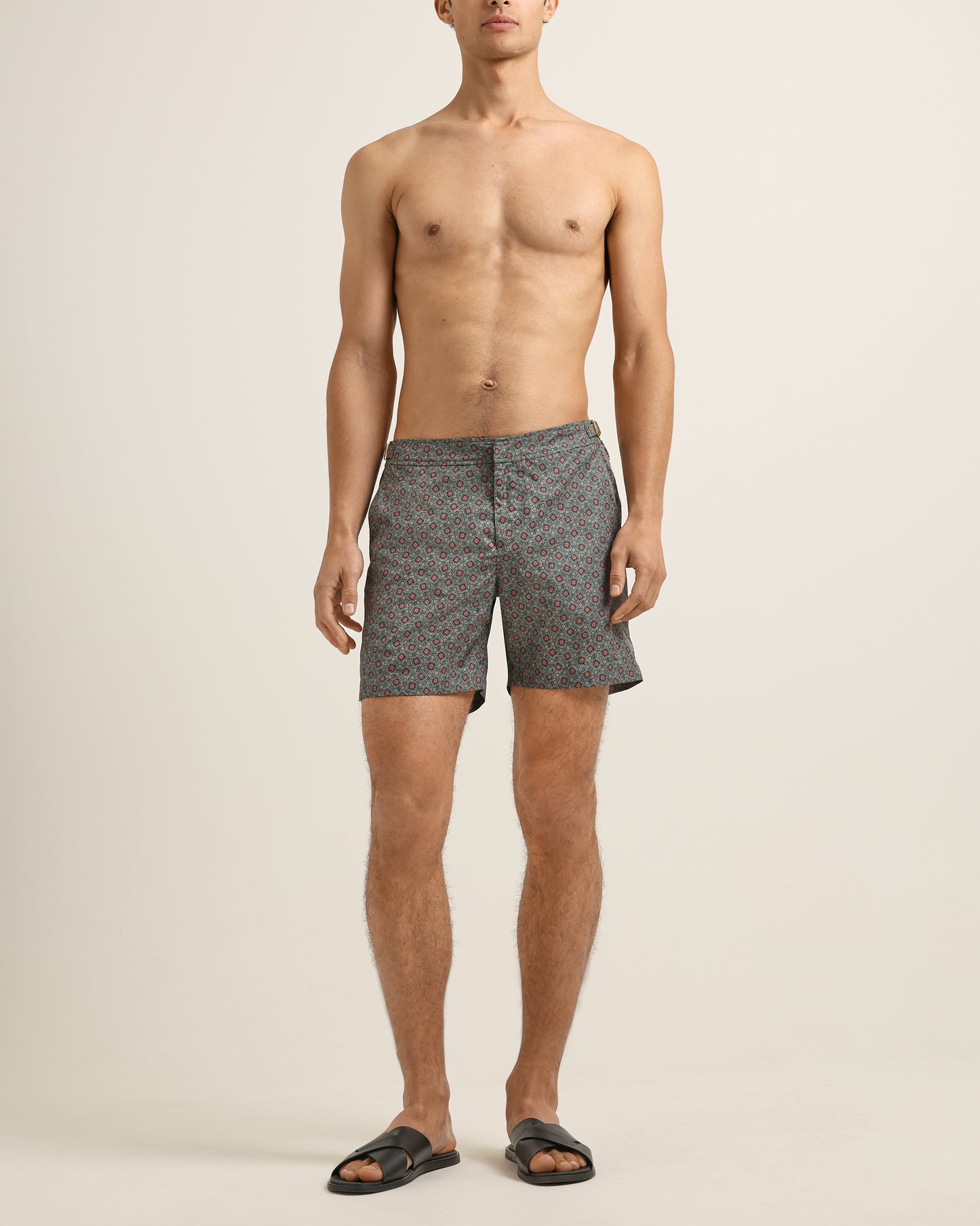 Man wearing patterned shorts on a beige background