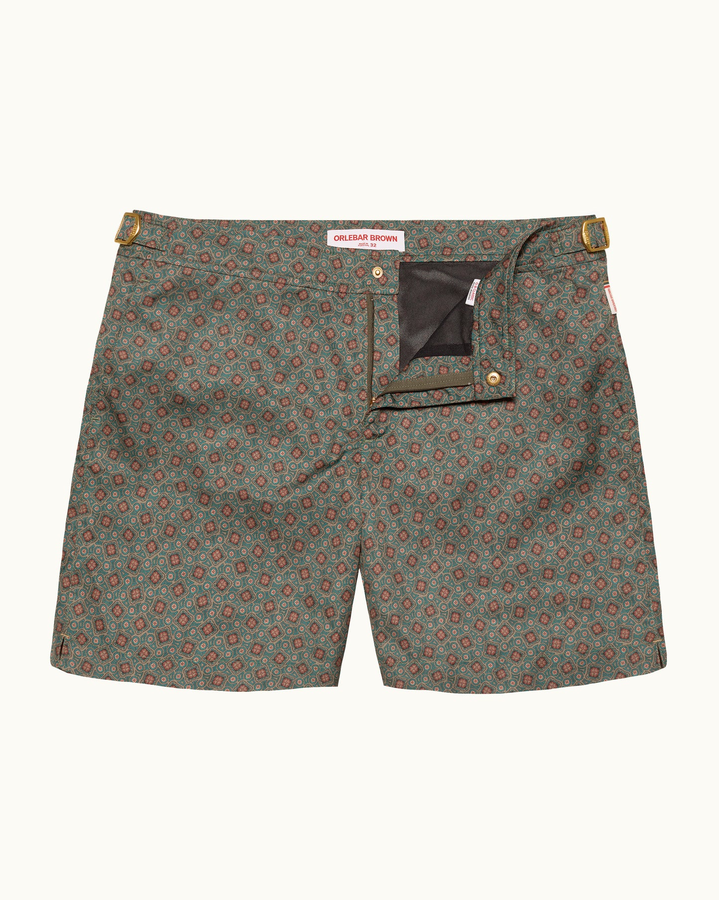 Green patterned shorts with gold buttons on a white background
