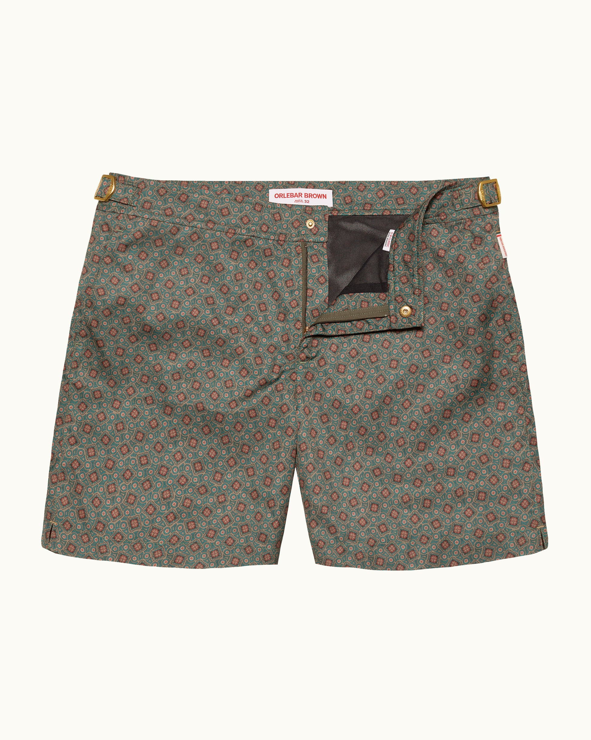 Green patterned shorts with gold buttons on a white background
