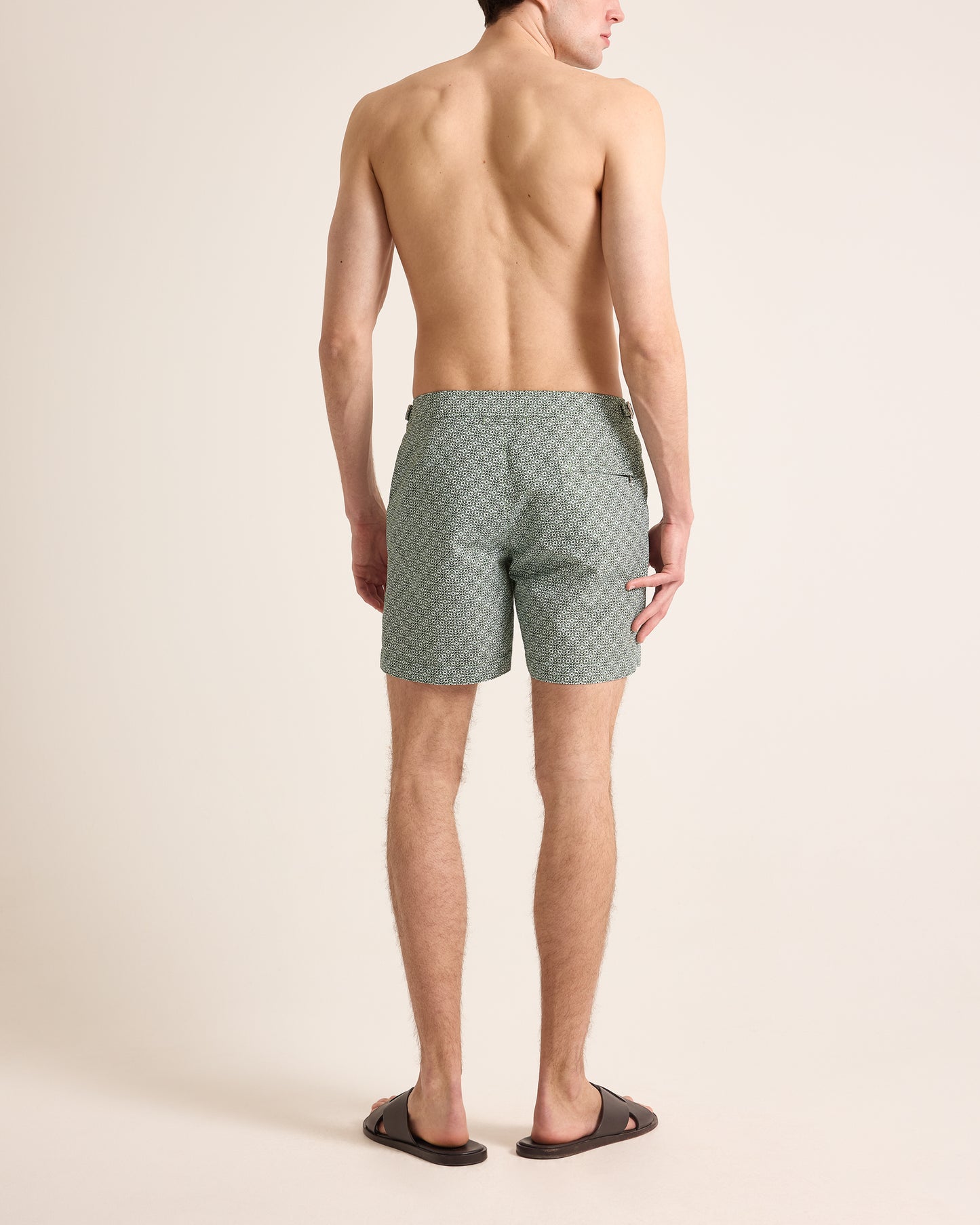 Man wearing green patterned shorts on a beige background