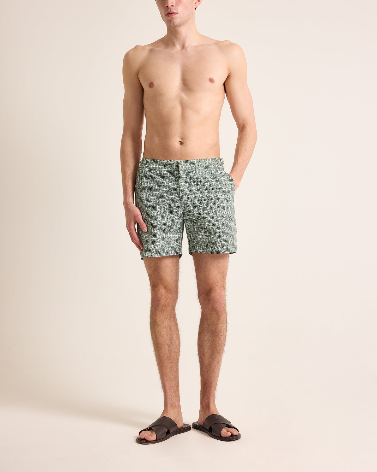 Man wearing green checkered shorts on a beige background
