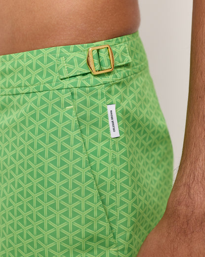 Green patterned shorts with a gold buckle and visible brand label.