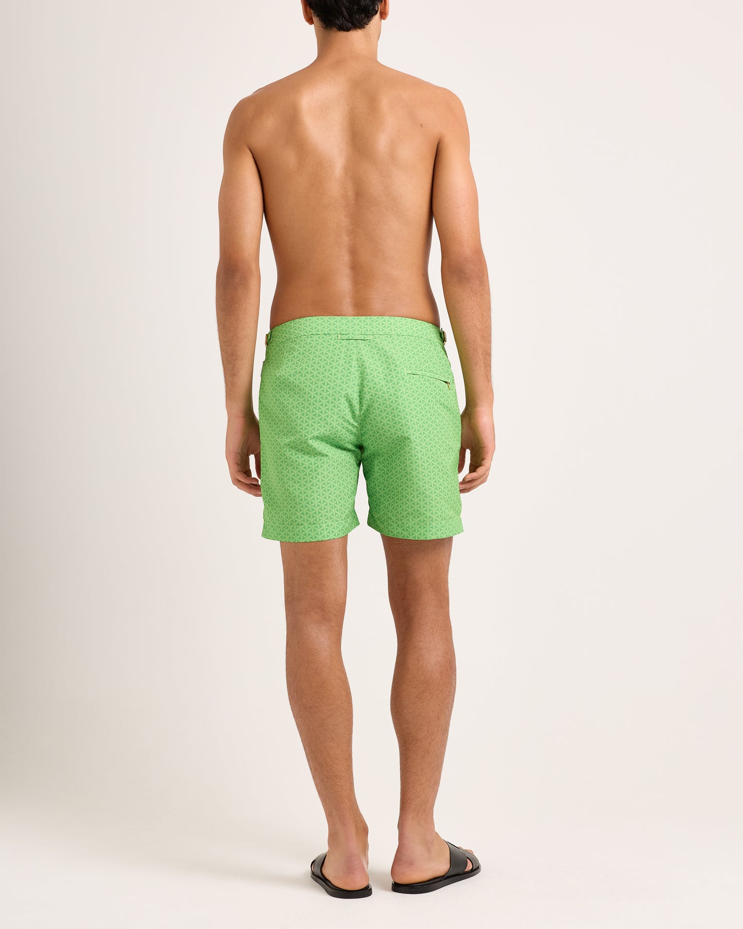 Person wearing green patterned shorts on a white background
