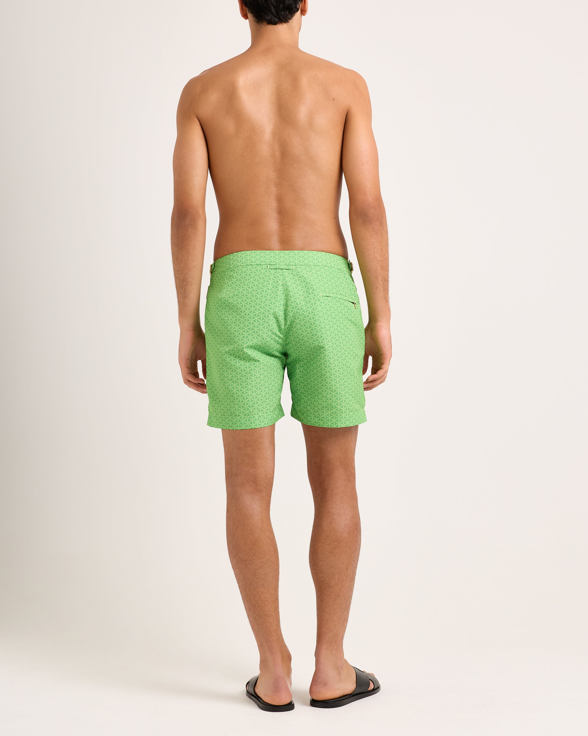 Person wearing green patterned shorts on a white background