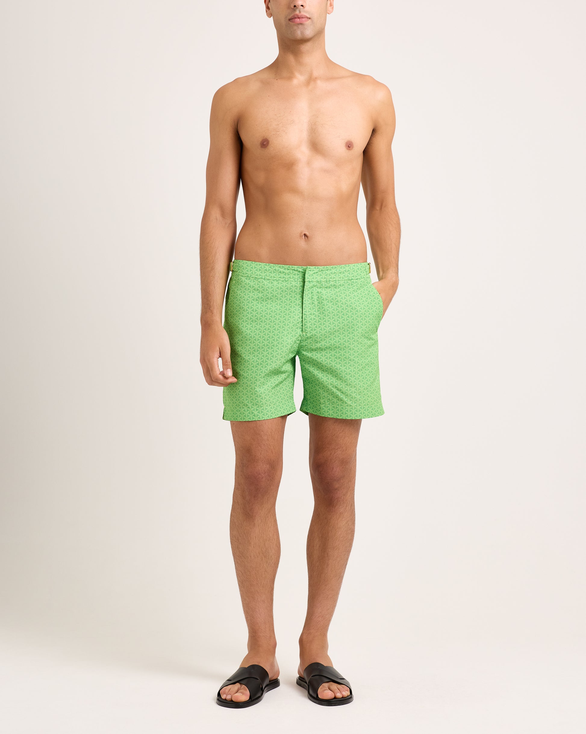 Man wearing green patterned shorts on a white background