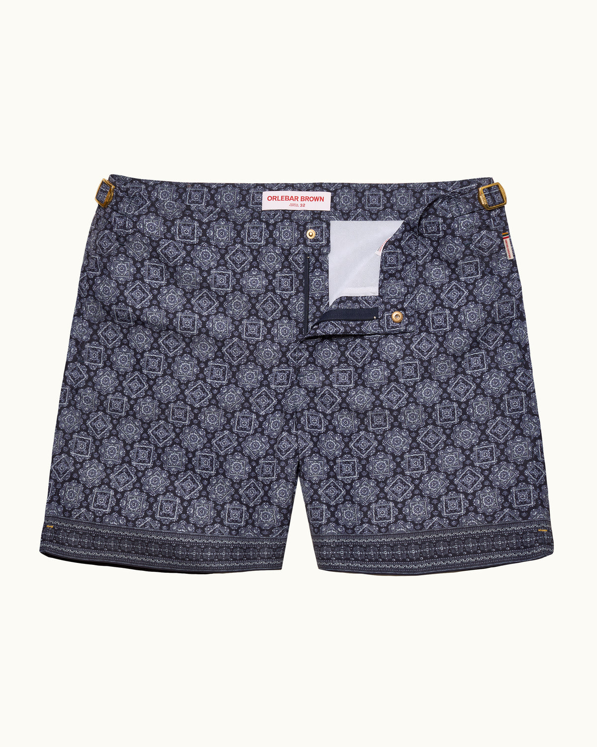 A pair of men's shorts featuring a dark navy blue and gray geometric pattern with a decorative border and gold-tone metal hardware.