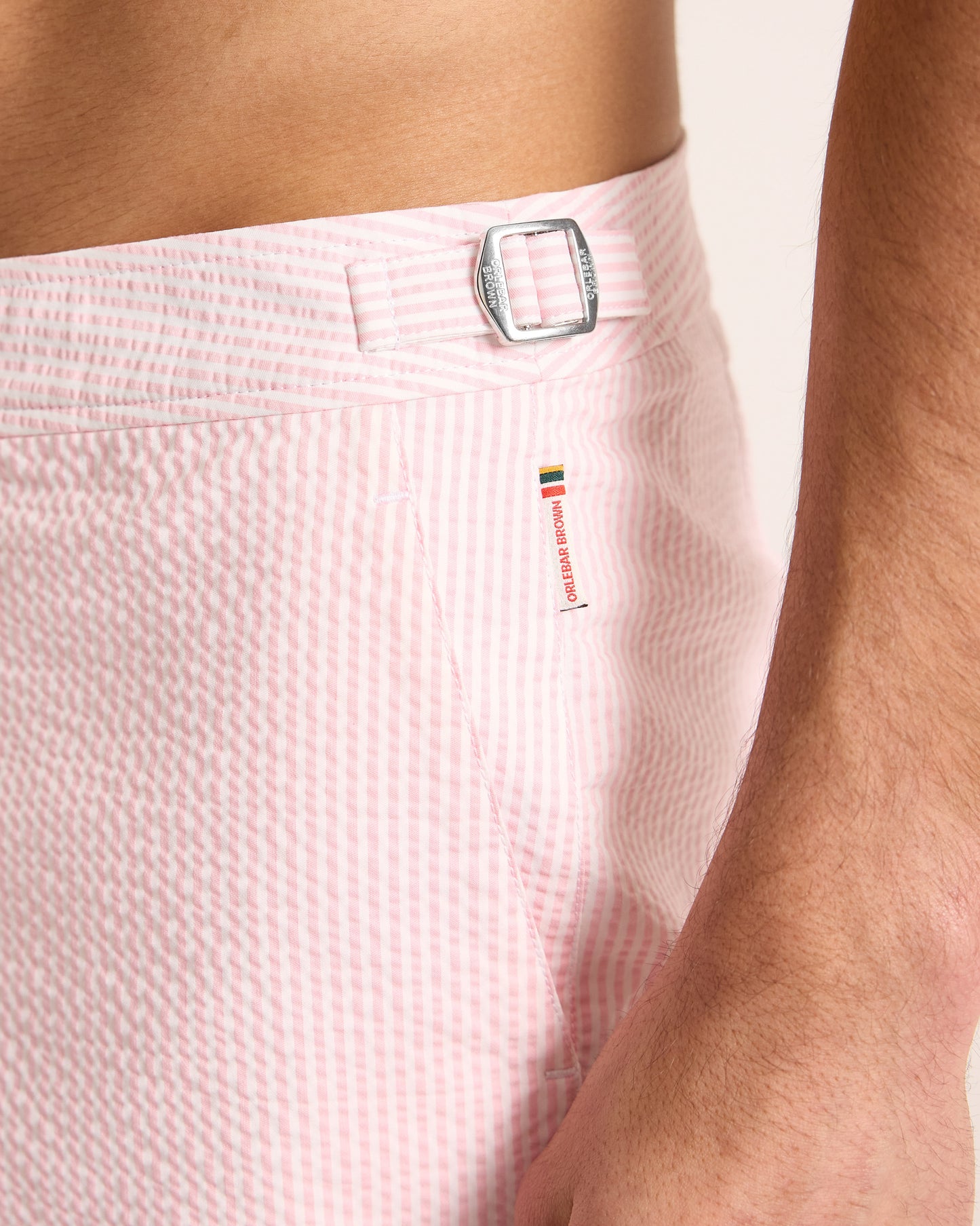 Close-up of pink shorts with a brand logo on a light background
