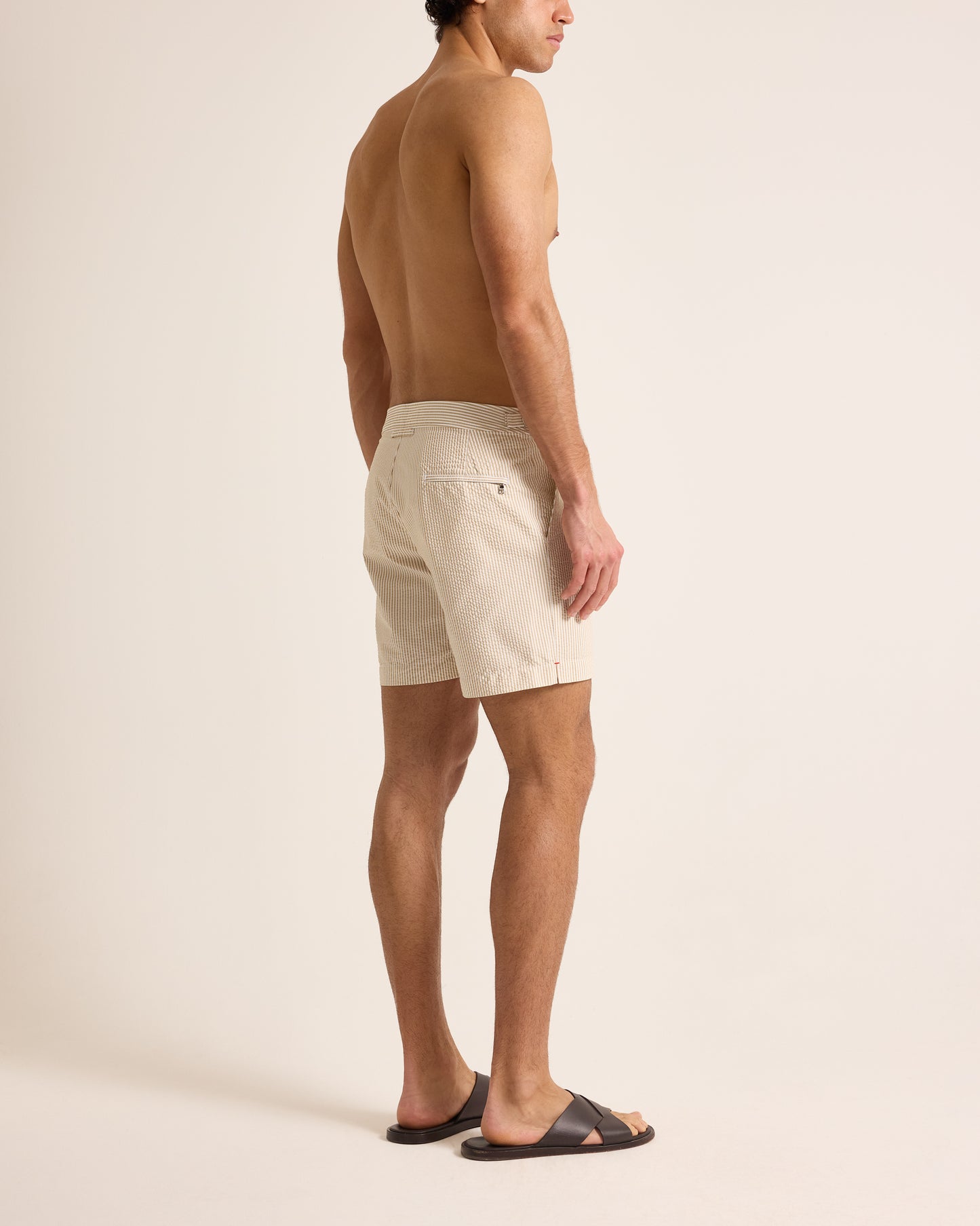 Man wearing beige shorts on a plain background
