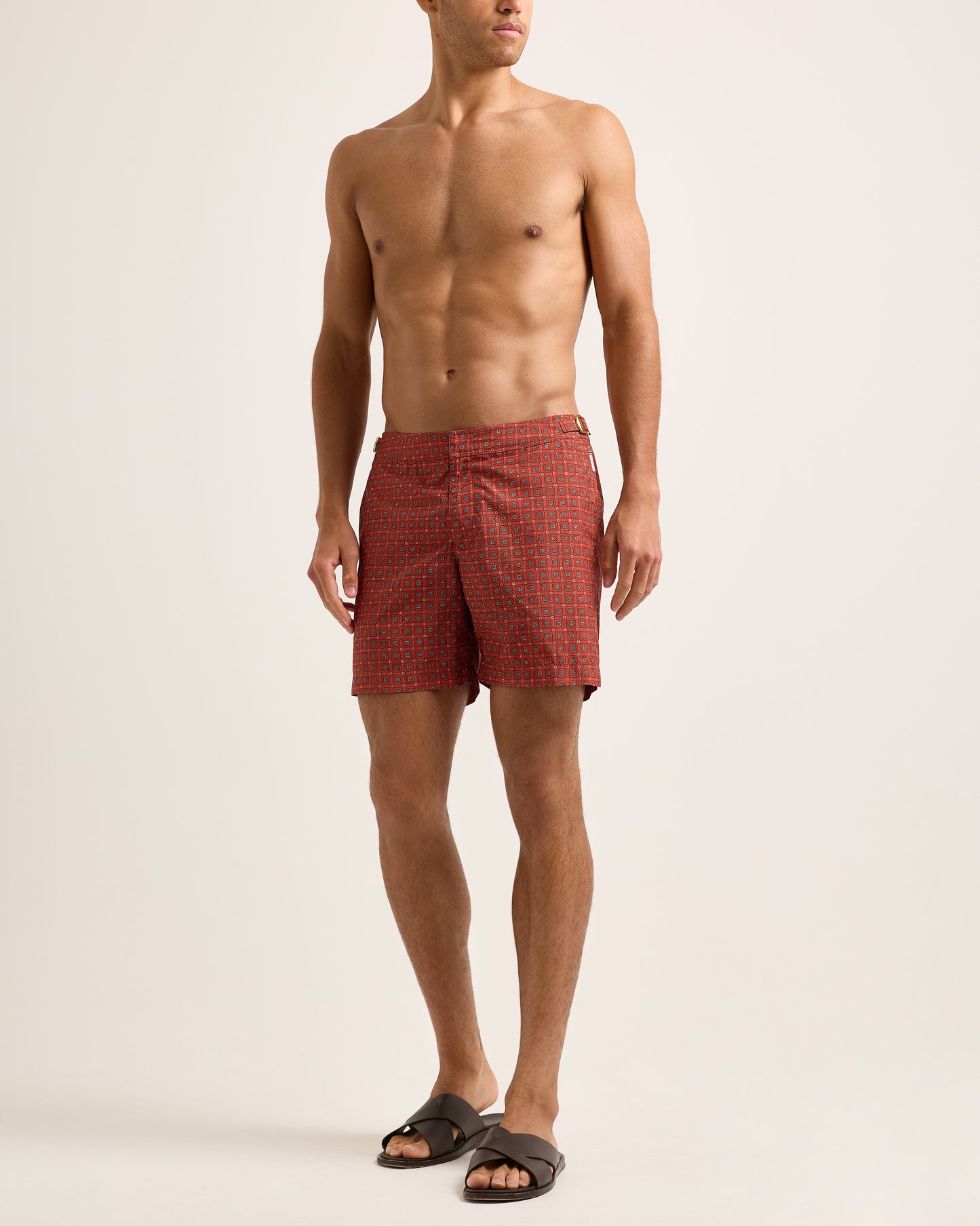 Man wearing Red swim short with geometric print on a white background