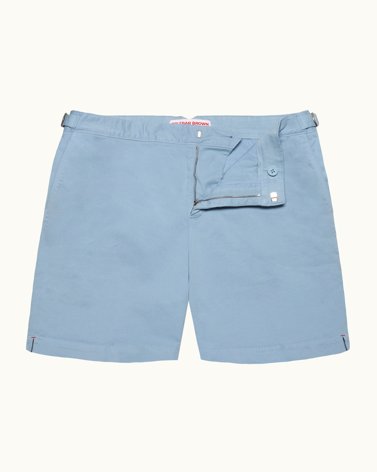 Blue swim shorts with silver side adjusters on a plain background
