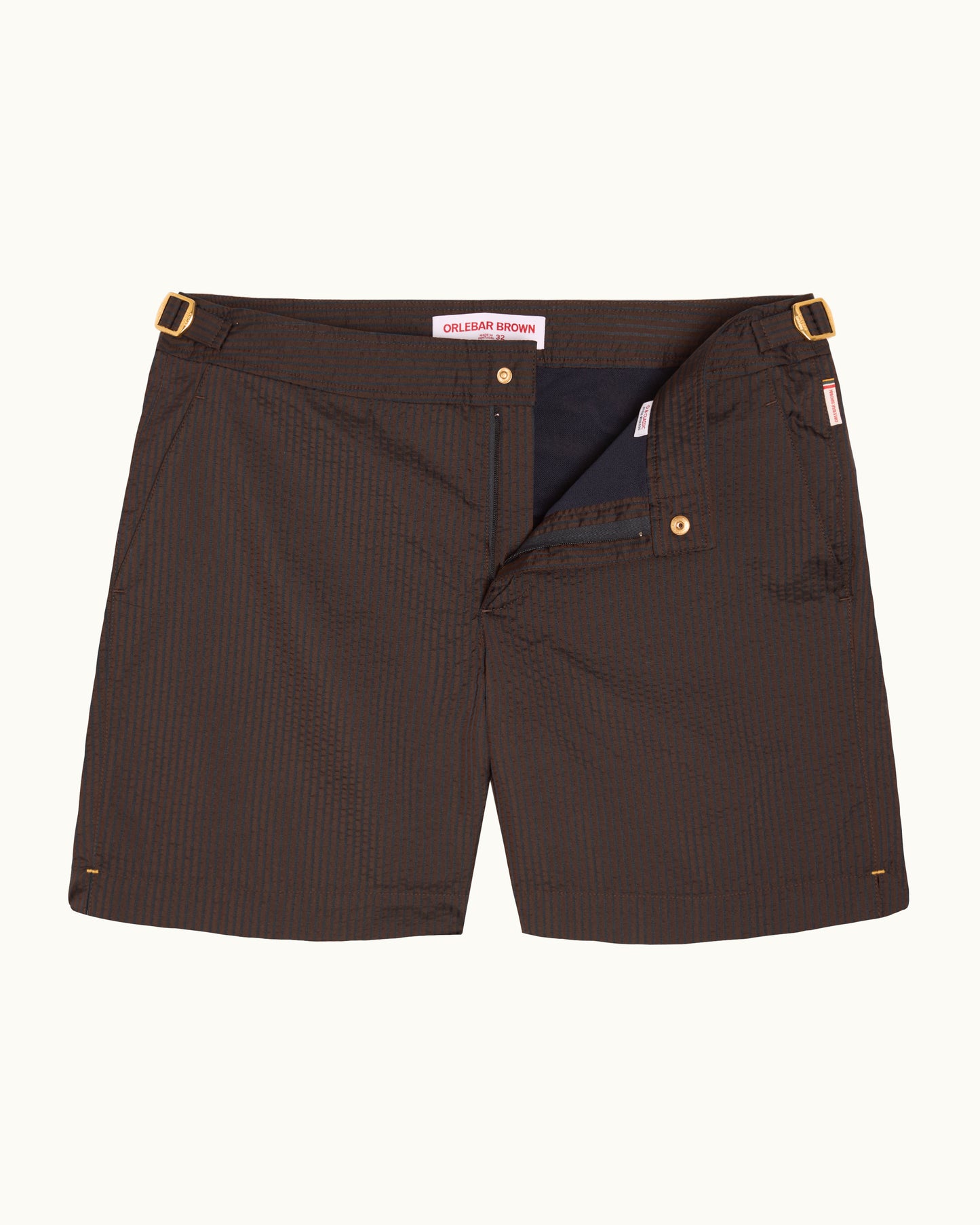 A pair of dark brown pinstriped shorts with gold-tone metal hardware, shown flat against a light off-white background