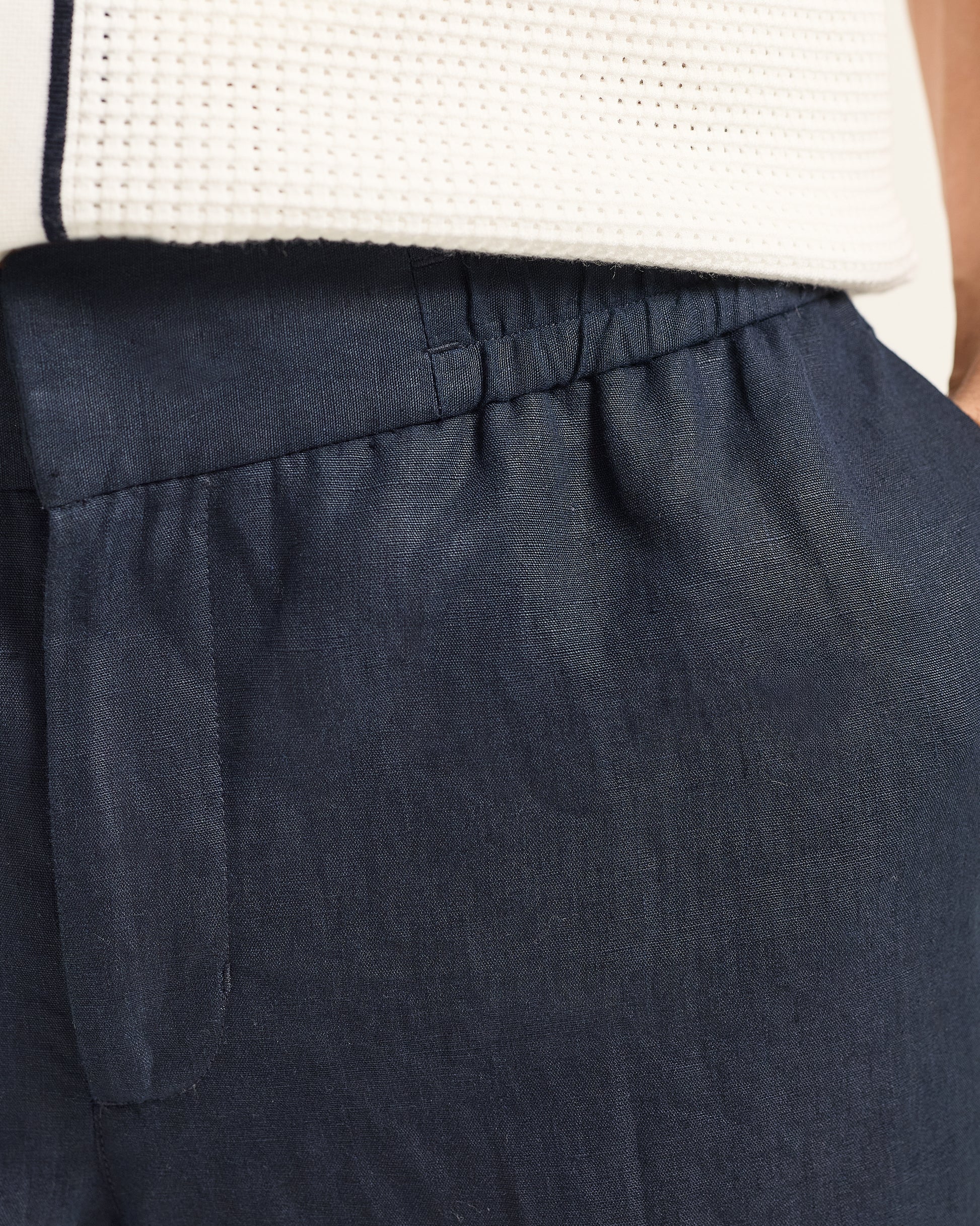Navy blue pants with a white top worn by a person
