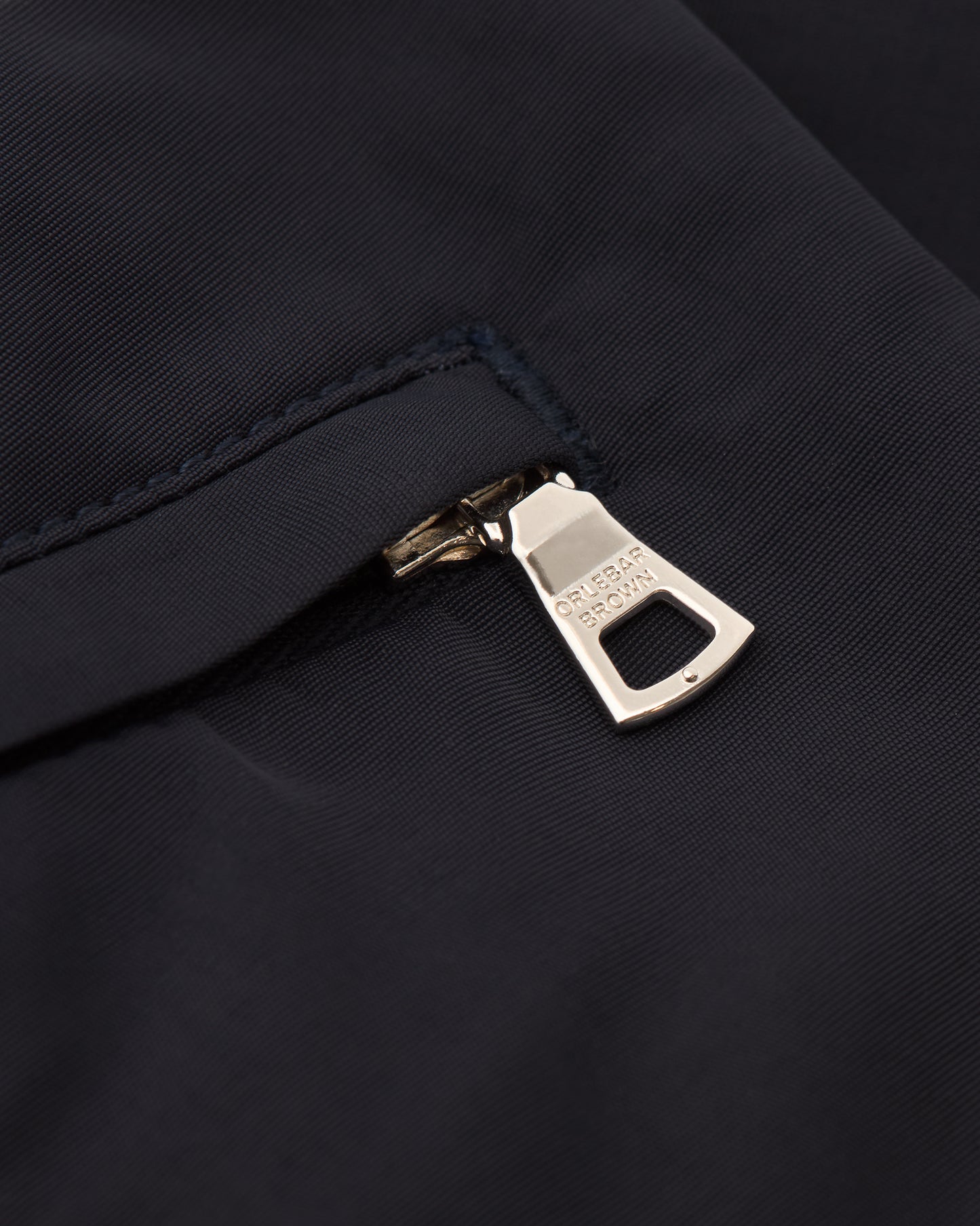 Close-up of a zipper on a dark fabric background