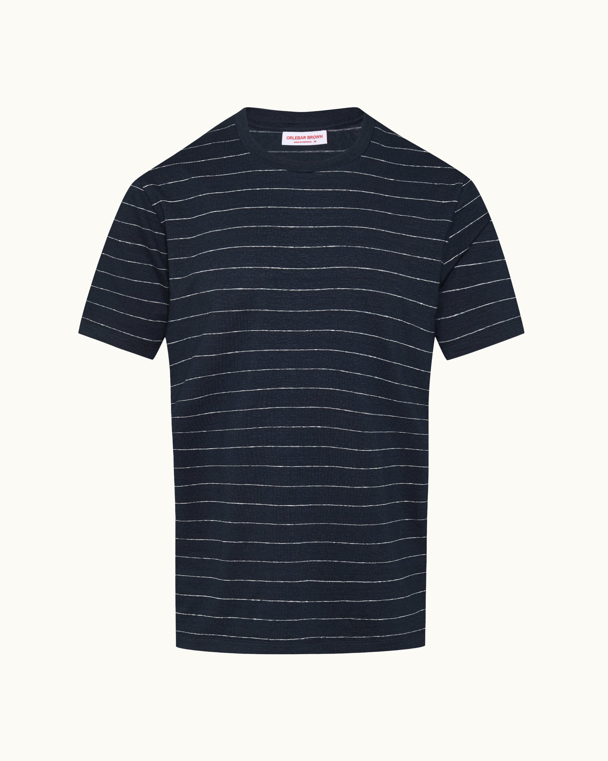A navy blue short-sleeve crewneck t-shirt with thin white horizontal stripes, displayed flat against a light cream background.
