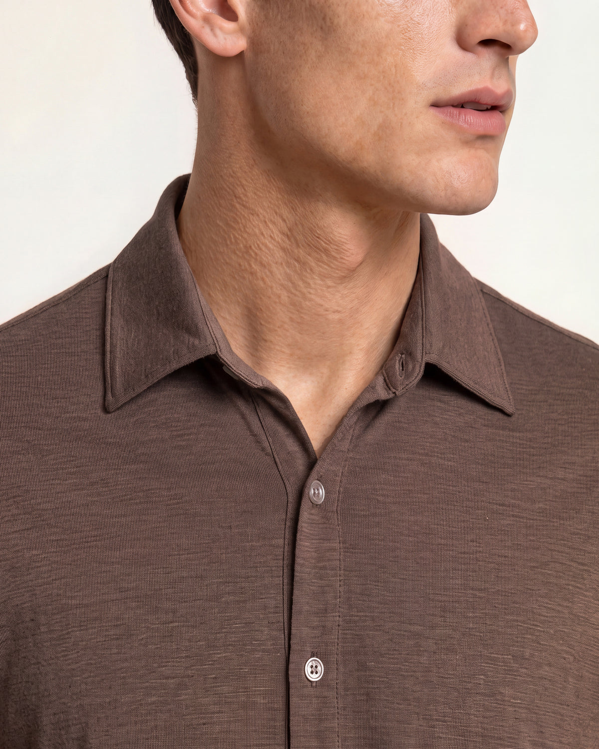 Closeup of brown merino shirt on a plain background