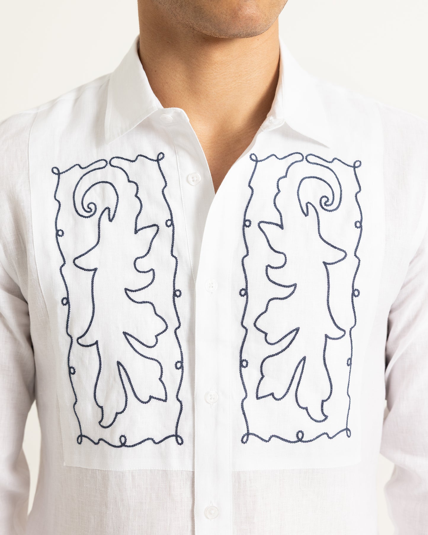 White shirt with black embroidered designs on a white background