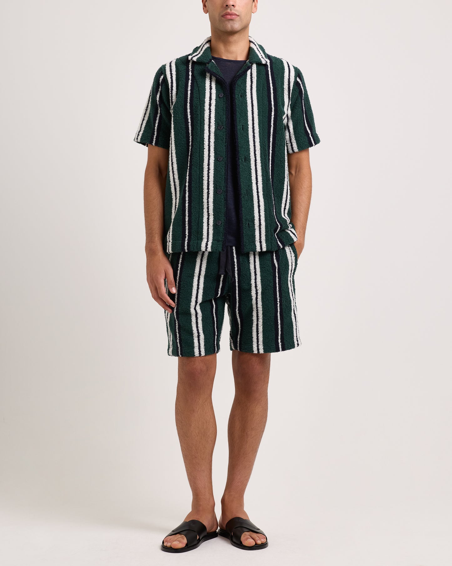 Model wearing green and white striped towelling shirt with matching shorts on a white background
