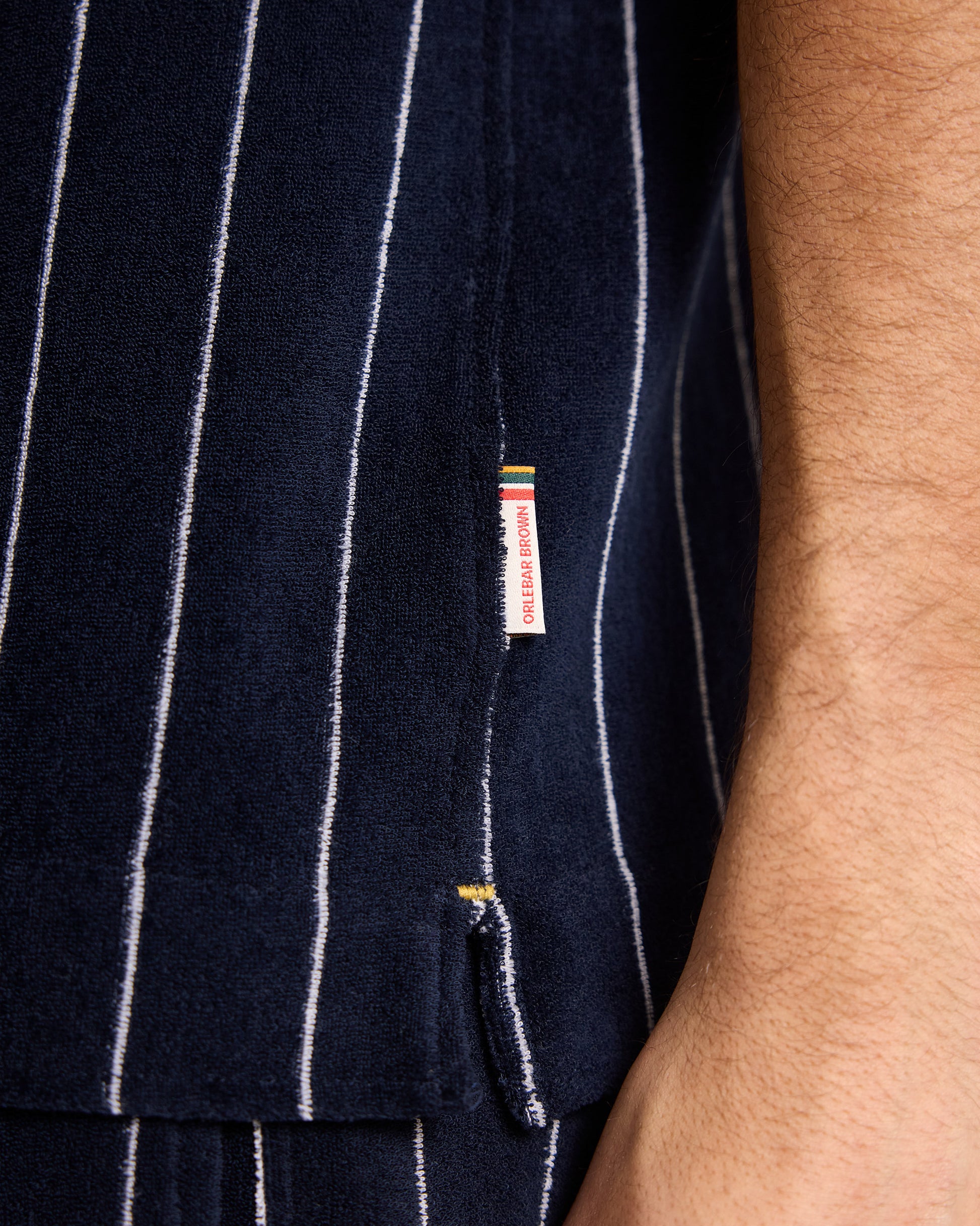 Navy pinstripe shirt with a brand label on a person wearing it.